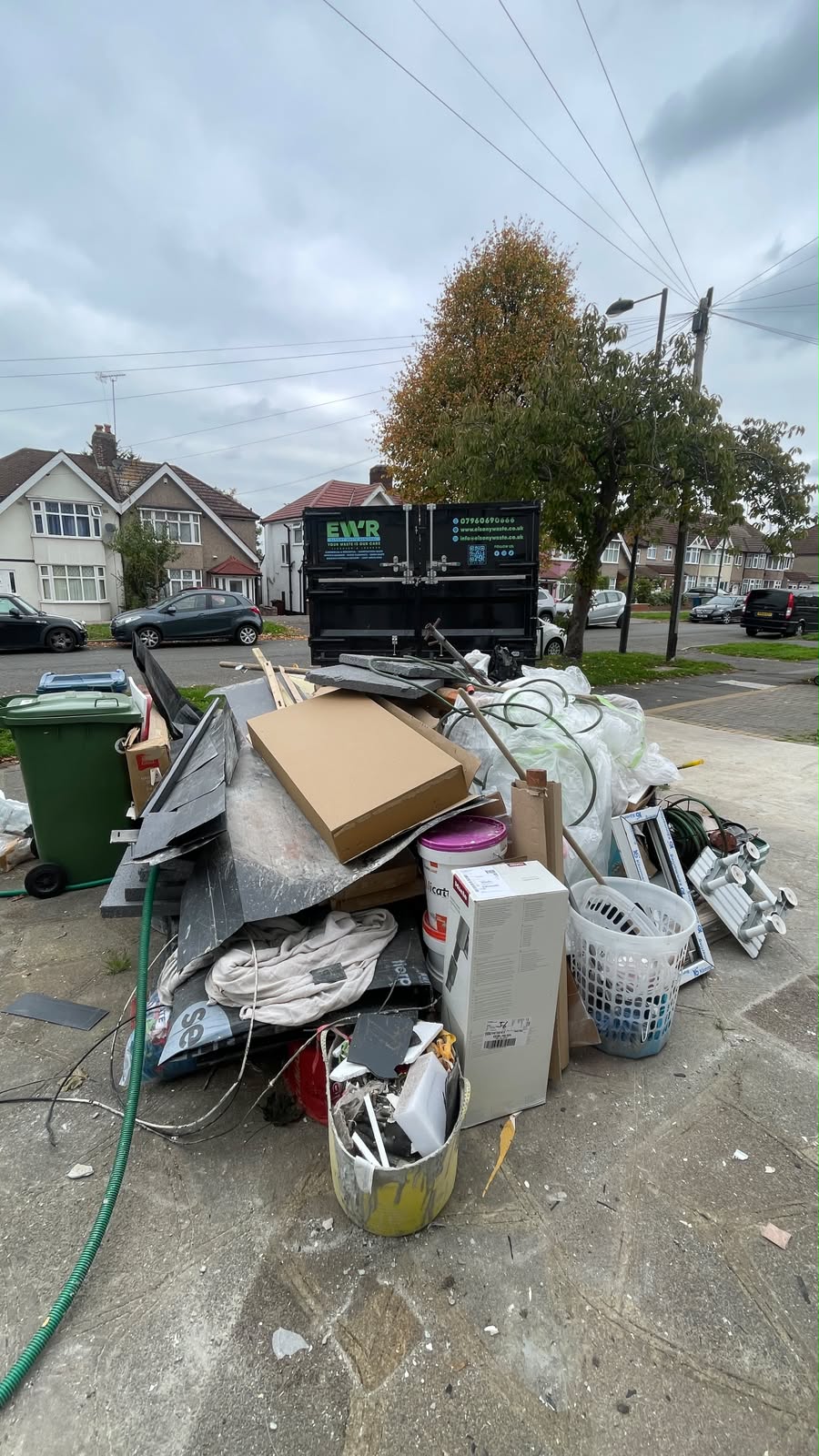 Pile of builders waste and rubbish bags on the pavement before collection