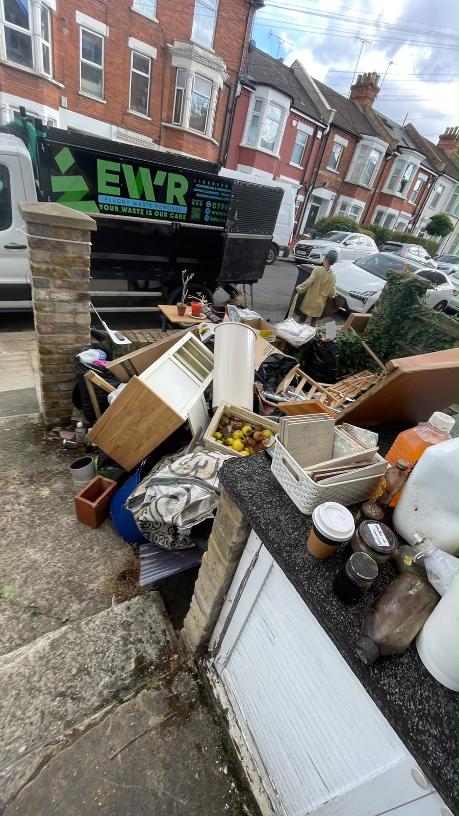 Household clearance waste piled on a driveway before collection